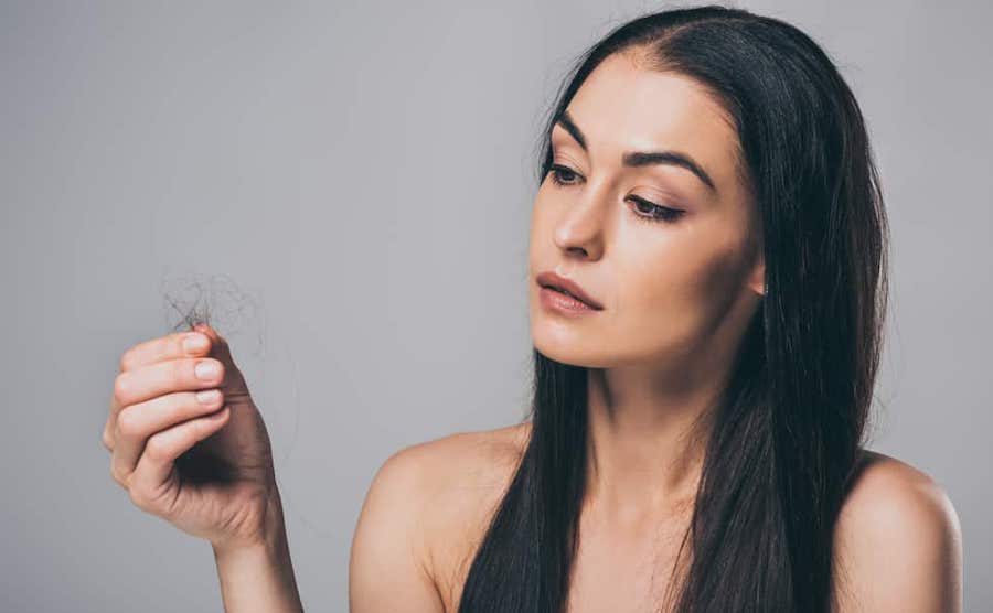 Telogen effluvium woman looking at hair
